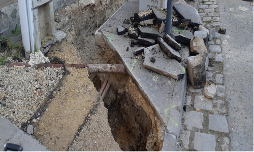 photo d'une excavation sur un chantier de travaux public avec contournement de tuyaux de réseaux